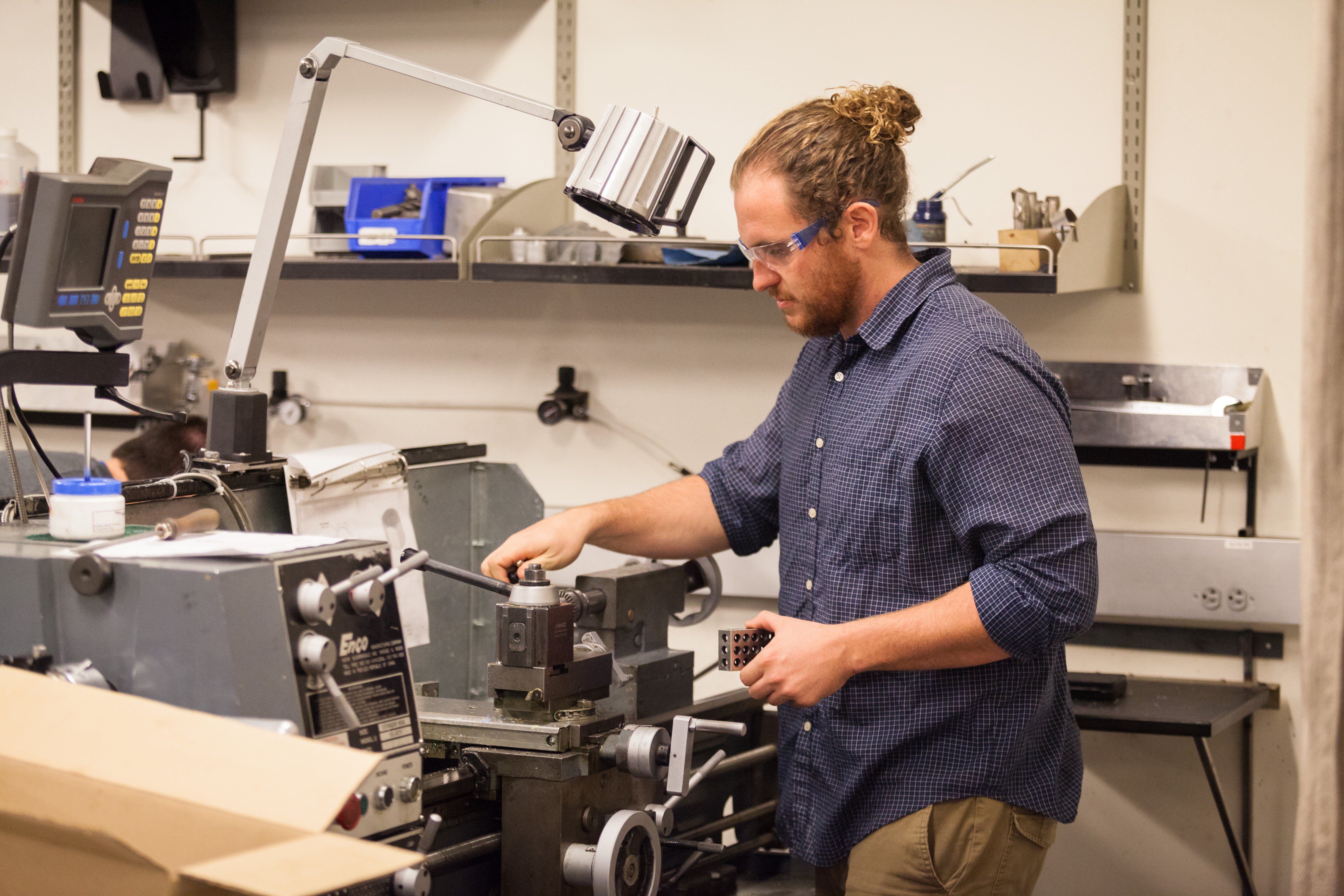 Student using a machine for engineering.
