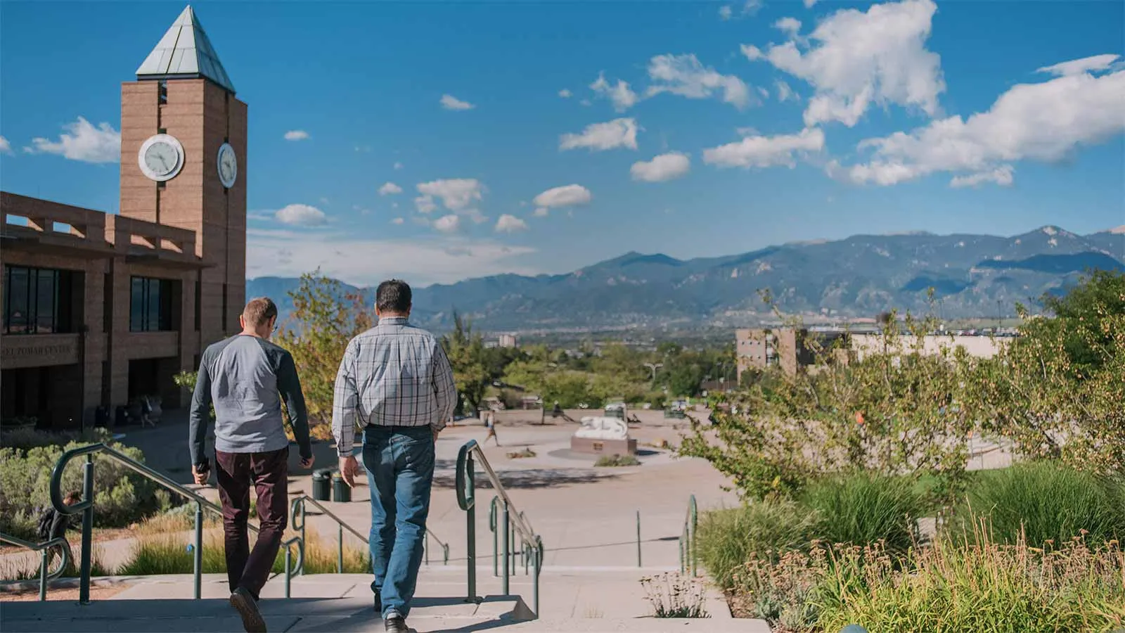 parent and student walking down the steps in El Pomar Plaza